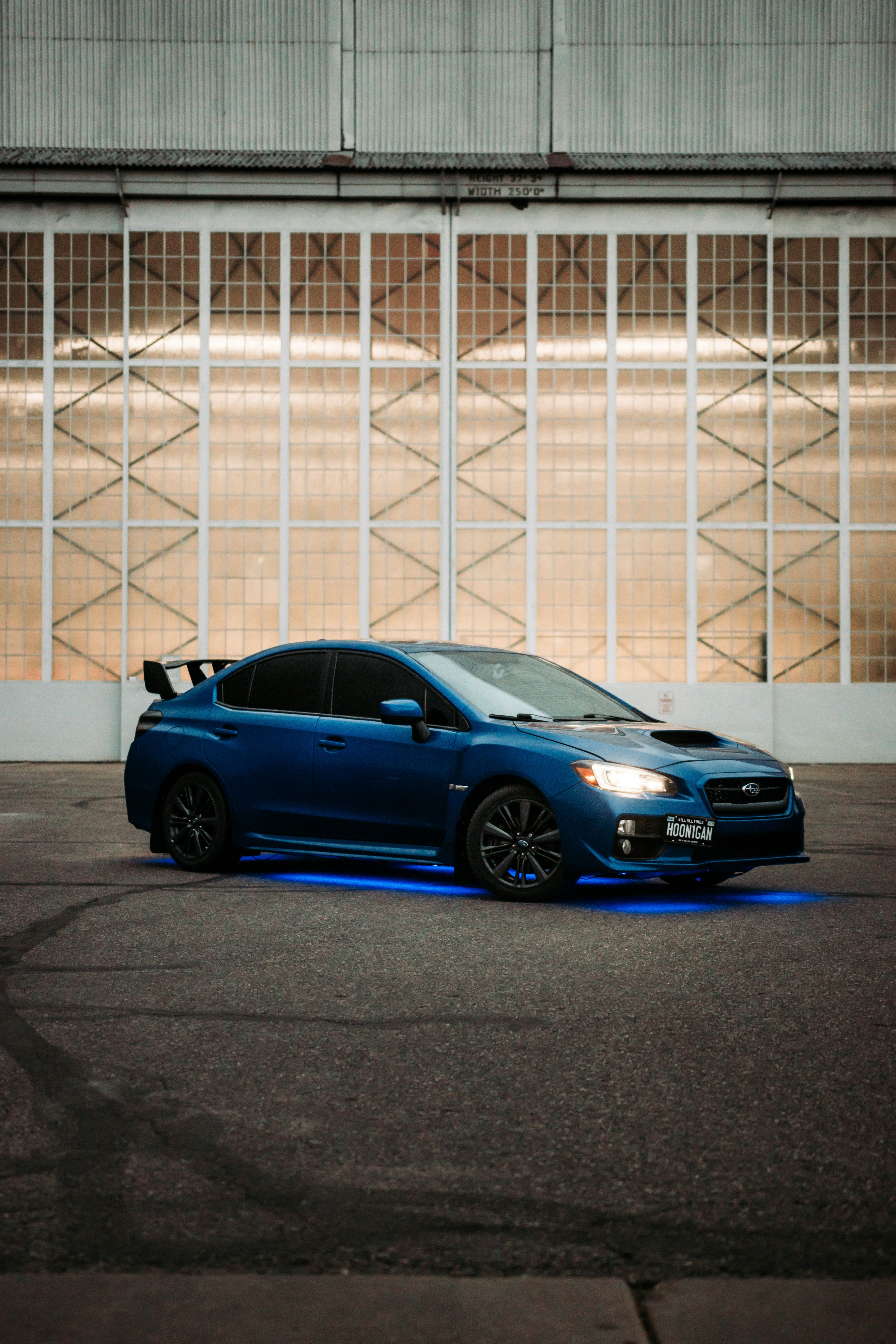 blue bmw m 3 coupe parked in front of white metal fence